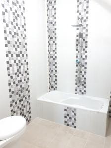 a white bathroom with a tub and a toilet at Villa Fifari - 5 Kamar Tidur, 3 Kamar Mandi in Batu +23 photos