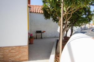 a building with a tree on the side of a street at Casa dos Avós in Villa Nogueira