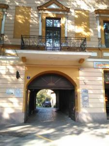 a building with a tunnel with a car driving under it at Miha Apartman in Subotica