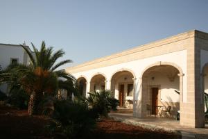 a building with a palm tree in front of it at Masseria San Martino in Fasano