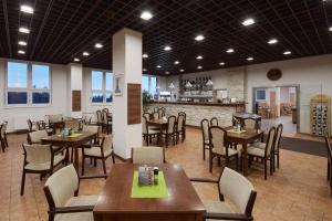 a restaurant with tables and chairs and a bar at Hotel Červenohorské sedlo in Loučná nad Desnou