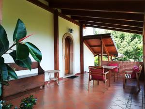 eine Veranda eines Hauses mit einem Tisch und Stühlen in der Unterkunft La dimora di Radha B&B Centro Olistico in Rende