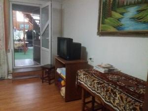 a living room with a tv on a dresser with a table at Erisia in Horezu