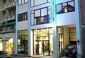 ein Gebäude mit Glasfenstern an einer Stadtstraße in der Unterkunft Hotel Balbo in Turin