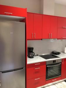 a kitchen with red cabinets and a stove top oven at Acropolis brand new 1min from metro! in Athens