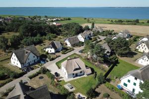 an aerial view of a village with houses and the ocean at Ferienhaus VINETA Schneckenhus LODDIN in Loddin