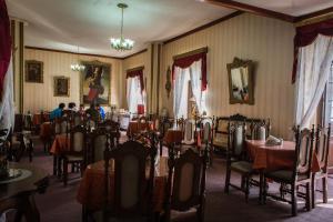 uma sala de jantar com mesas e cadeiras e um lustre em Hostal Sucre em Sucre