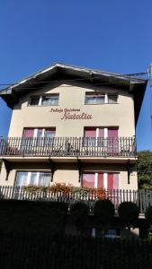 a building with a balcony with flowers on it at Pokoje Goscinne Natalia in Władysławowo