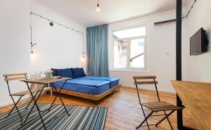 索非亞的住宿－Generaator Sofia，客厅配有蓝色的床和一张桌子
