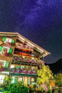 un edificio con cajas de flores en el balcón por la noche en Gästehaus Fritz, en Mittelberg