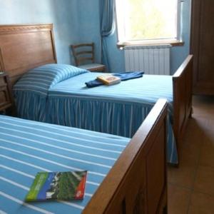 een slaapkamer met 2 bedden en een stoel. bij Bellegarde in Saint-Gauzens