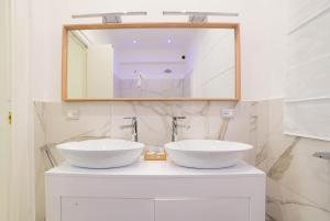 y baño con espejo y 2 lavabos blancos. en Luxury Suite Corso Umberto, en Taormina