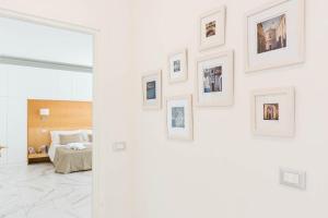 Habitación con cama y cuadros enmarcados en la pared en Luxury Suite Corso Umberto, en Taormina 7 fotos más