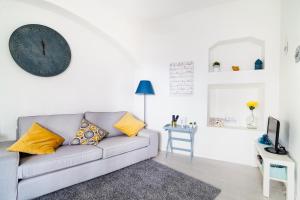 - un salon avec un canapé et un réveil sur le mur dans l'établissement Poet's house in historic center, à Évora