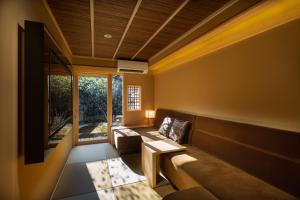ein Wohnzimmer mit einem Sofa und einem Tisch in der Unterkunft Tsumugi Sanjusangendo in Kyoto