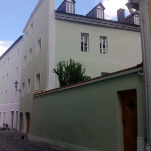 a large white building with a green and white facade at Ferienwohnungen am Dreiflüsseeck in Passau