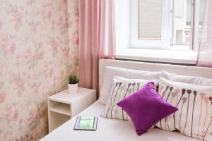 モスクワにあるApartment Nice Life near Kremlinのベッドルーム1室(紫色の枕が付くベッド1台、窓付)