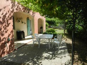 una mesa blanca y sillas sentadas bajo un árbol en L'Oliveraie, en Draguignan