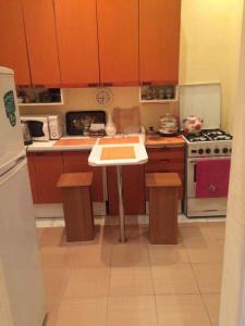 a kitchen with wooden cabinets and a white table in it at Apartment Niyazi 5 in Baku