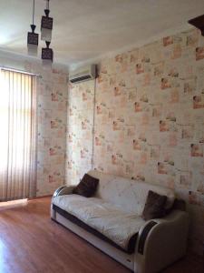 a couch in a room with a brick wall at Apartment Niyazi 5 in Baku