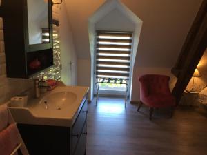 a bathroom with a sink and a red chair at La Ressource in Fontguenand +15 photos