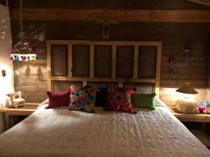 uma cama com almofadas coloridas num quarto em Zoyatl - Xamikal em Zacatlán