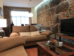 Sweet Home Pontevedra في بونتيفيدرا: غرفة معيشة مع أريكة وتلفزيون