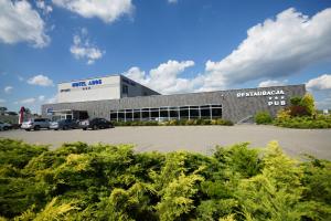 a large building with cars parked in a parking lot at Hotel Aros in Tychy