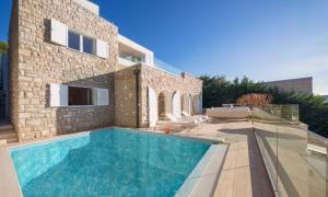 a swimming pool in front of a house at Apartments Coral in Primošten