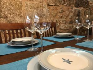 Sweet Home Pontevedra في بونتيفيدرا: طاولة عليها كؤوس من النبيذ وأطباق