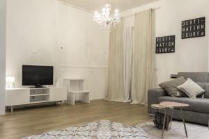 a living room with a couch and a tv at L'ULIVO - home suite in Bari