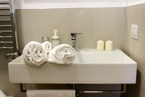 a bathroom with a sink with towels on it at L'ULIVO - home suite in Bari