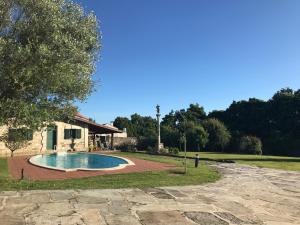 a swimming pool in a yard next to a building at Casa Rústica Piscina, Apartadiño in Pobra do Caramiñal