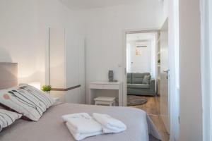 a white bedroom with two towels on a bed at Leona Deluxe Apartments in Pula
