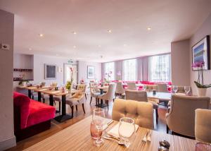 un restaurante con mesas y sillas en una habitación en The Highworth Hotel, en Swindon