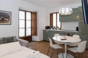 a kitchen and a living room with a table and chairs at Lasi house in Serra San Bruno
