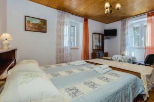 a bedroom with two beds and a desk and window at Guest House Robert i Mirna in Bale