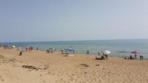 a group of people on a beach with umbrellas at Villa Salvatore in San Leone