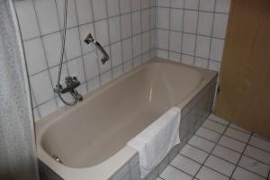 eine weiße Badewanne in einem weiß gefliesten Bad in der Unterkunft Ferienwohnungen-Goldbach Erdgeschoss in Regensburg