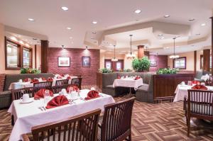 un restaurante con mesas y sillas con servilletas rojas en Albatross Hotel, en Gander