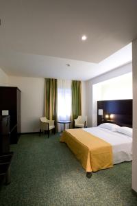 ゴルゴンゾーラにあるホテル セネターの大きなベッドと窓が備わるホテルルームです。