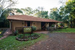 uma pequena casa com um sinal em frente em Iguassu Eco Hostel - IguassuEcoHostel - Eco Suítes em Foz do Iguaçu