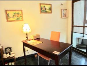 a room with a desk with a lamp and chairs at Sailin 137 Hostel in Tainan