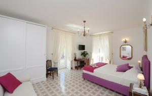 a hotel room with a bed, table, chairs and a mirror at Residenza Luce in Amalfi