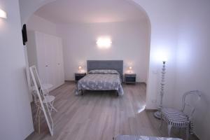 a bedroom with a bed and two chairs in it at Alloggio I Grifoni in Ferrara