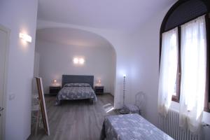 a bedroom with two beds and a large window at Alloggio I Grifoni in Ferrara