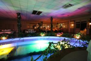 スタレッティにあるHotel Club Poseidonのテーブル付きの部屋の中央にプールがあります。