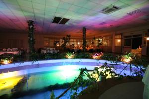 a pool in the middle of a room with a table at Hotel Club Poseidon in Stalettì