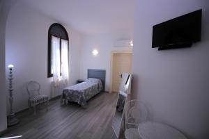 a bedroom with a bed and a television on a wall at Alloggio I Grifoni in Ferrara