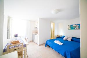 a bedroom with a blue bed and a kitchen at Dimora Storica La Torre Nel Borgo in Borgagne